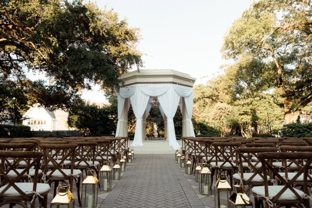 Elegant outdoor wedding ceremony with white gazebo and seating in New Orleans.
