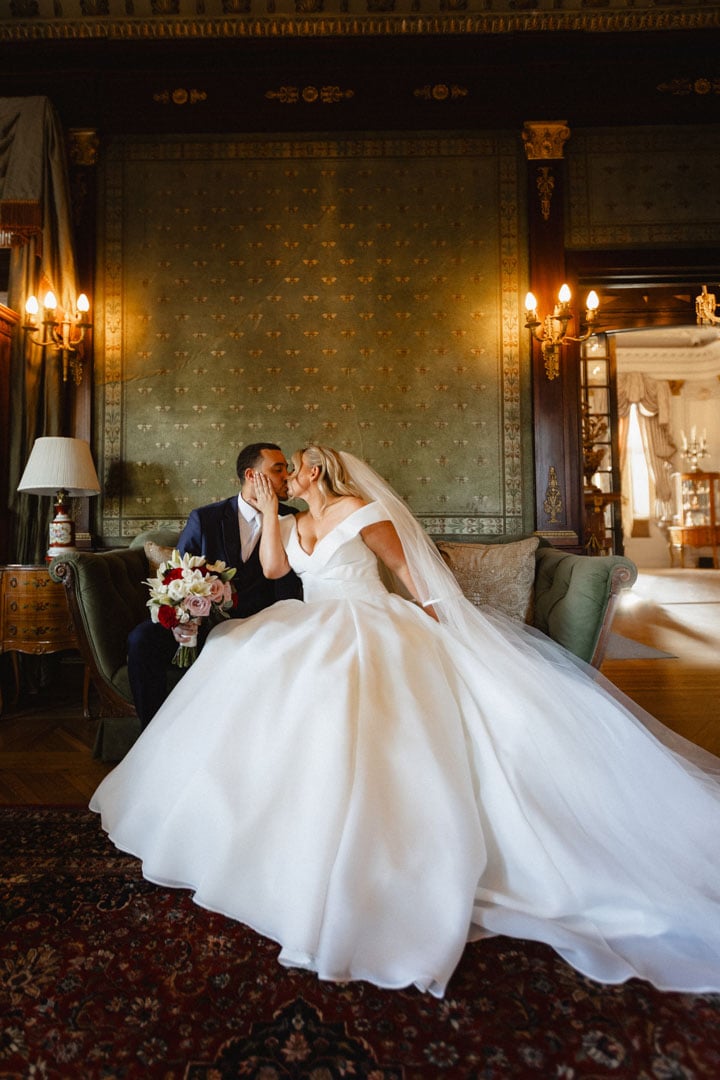 Bride and groom sharing a kiss in elegant historic venue in New Orleans.