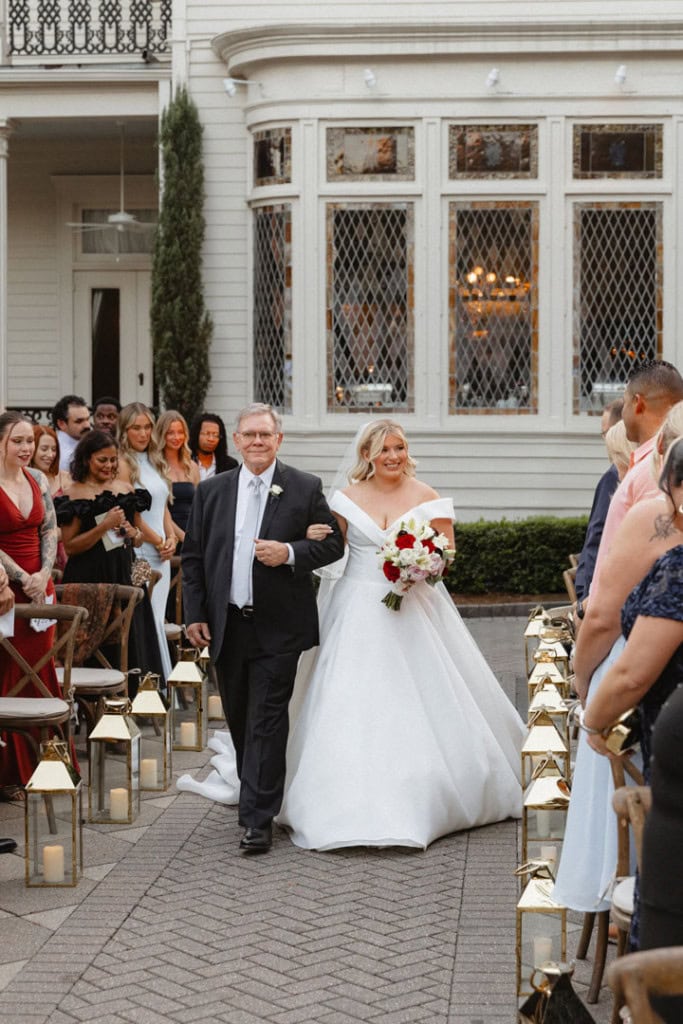 Bride walking down aisle with father at New Orleans wedding.