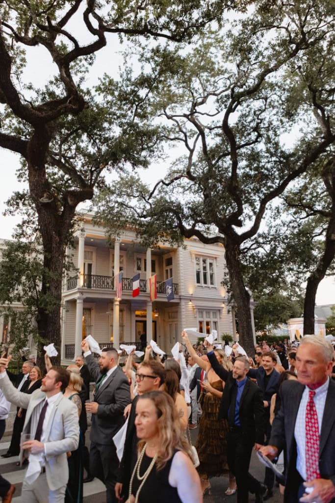 Wedding guests celebrating outdoors in front of a historic New Orleans building.