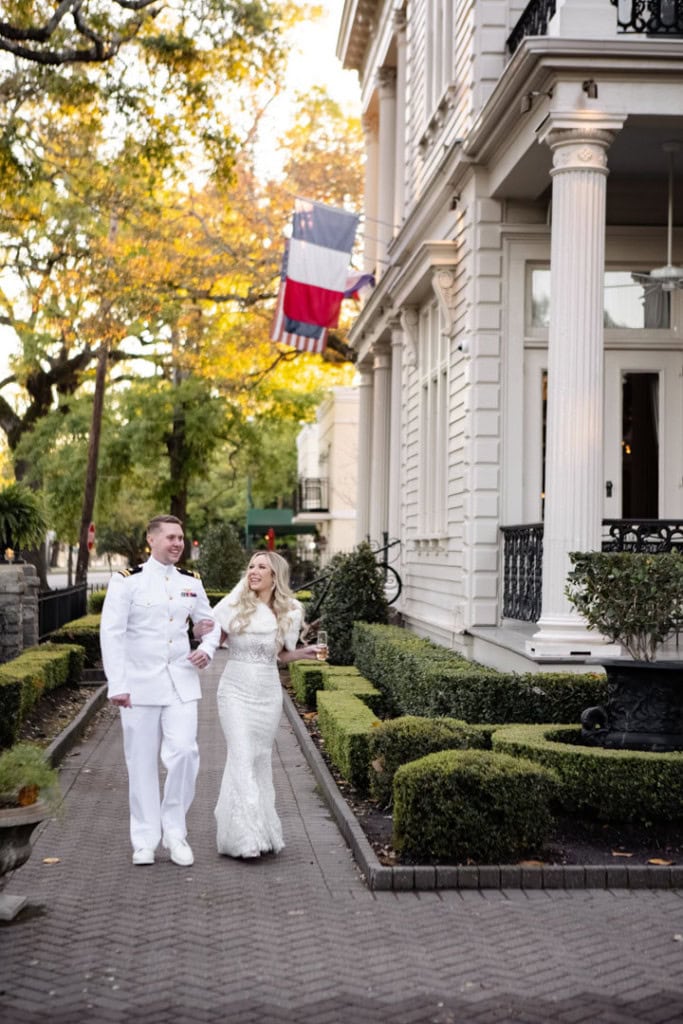 Bride and groom walking in historic New Orleans street with French flag.