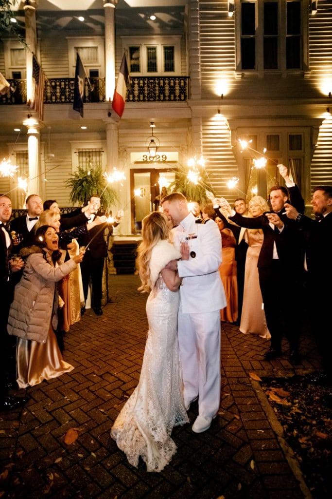 Bride and groom dancing outside with guests at night in New Orleans.