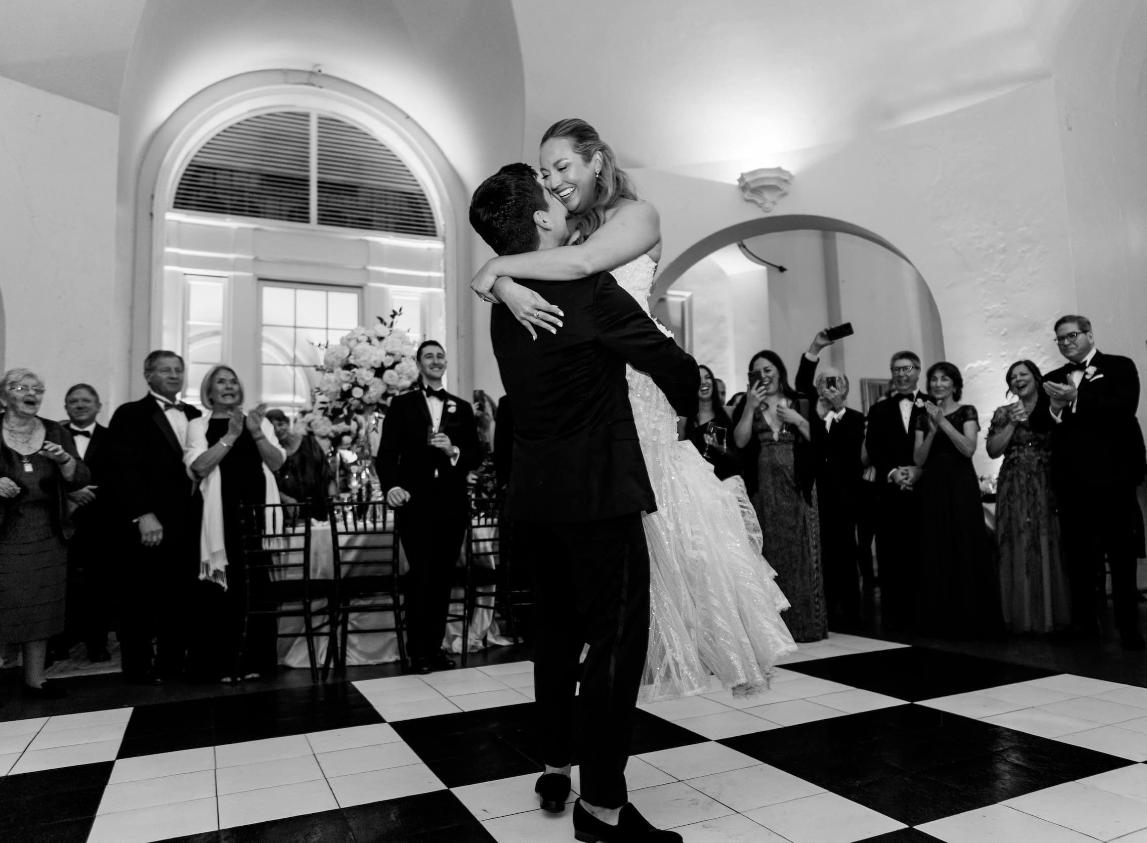 Black and white image of a groom as he lifts the bride during their wedding reception at Latrobe's in New Orleans.