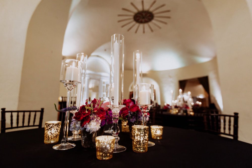 Wedding reception table with candles and floral arrangements in New Orleans venue.