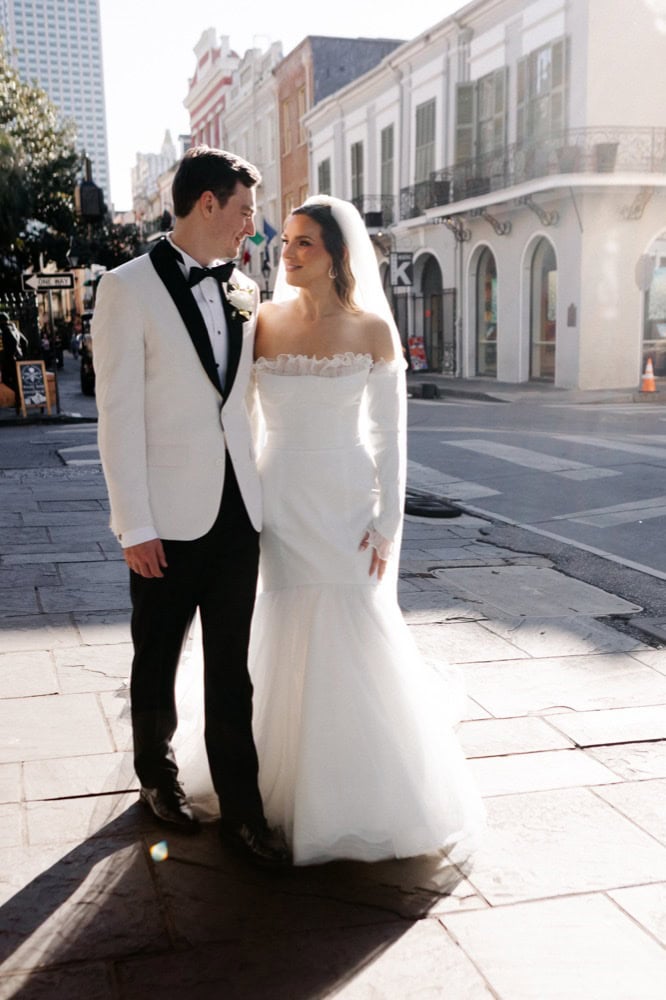 Couple in wedding attire on a city street in the French Quarter in New Orleans.