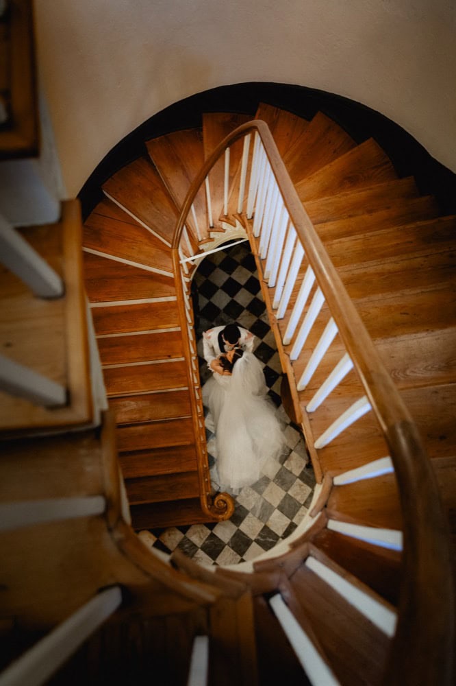 Bride and groom on spiral staircase during wedding in New Orleans.