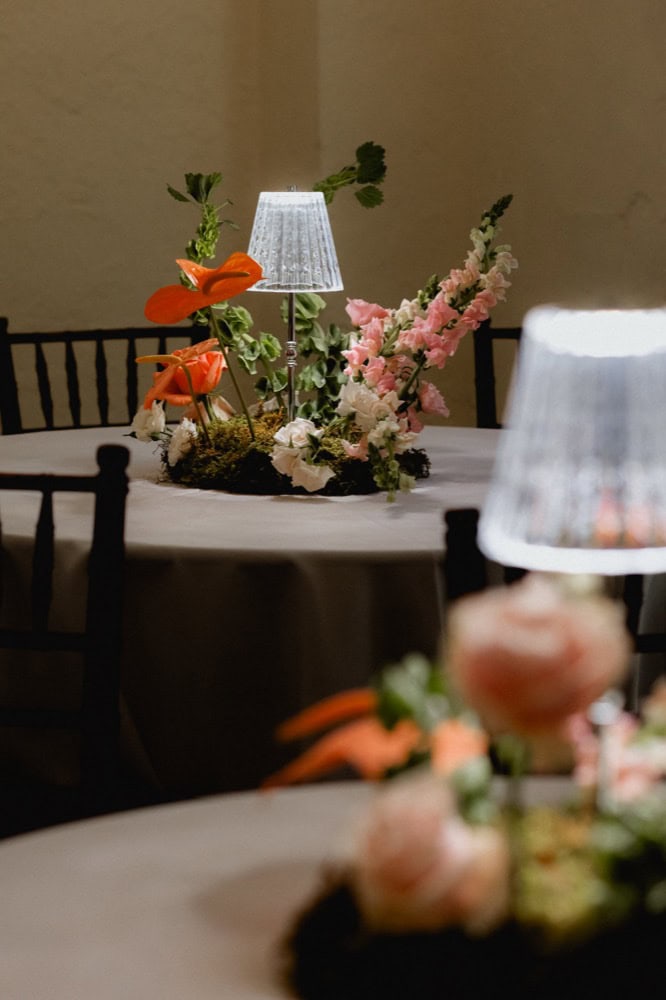Beautiful wedding table centerpiece with flowers and lamps in New Orleans venue.