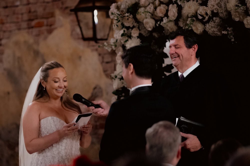 Bride and groom exchanging vows at New Orleans wedding with officiant and floral decor.