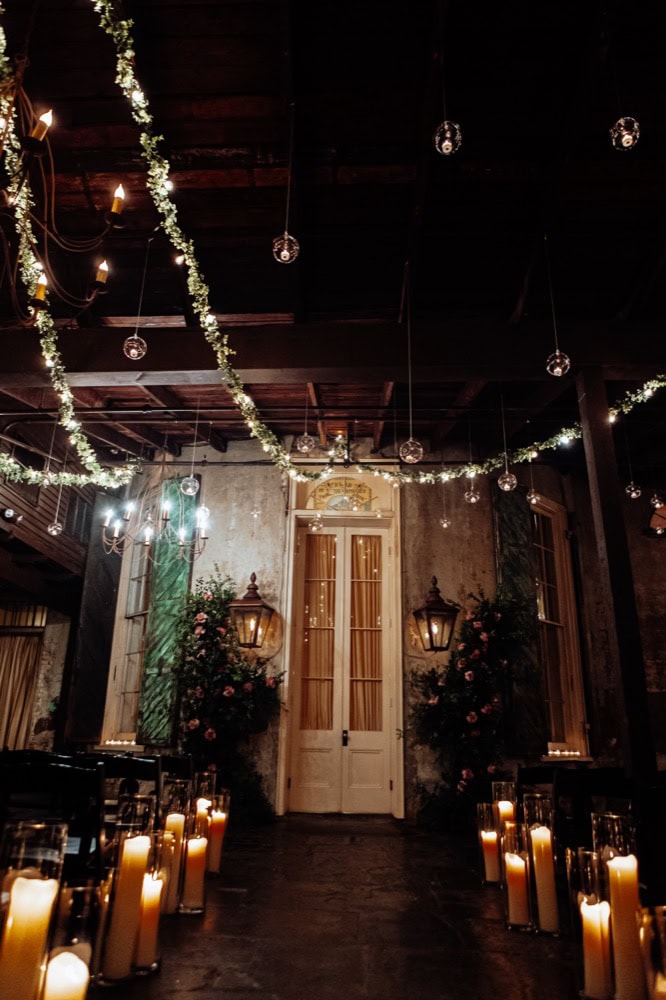 Elegant wedding venue with candles, floral arrangements, and string lights.