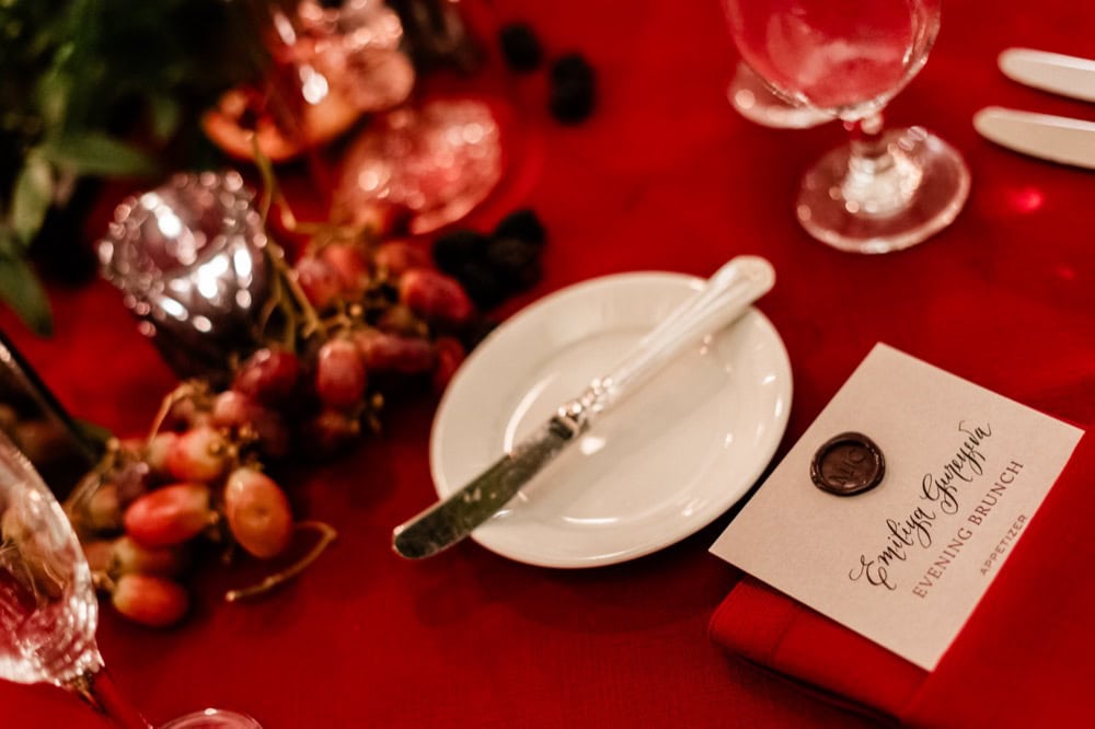 Wedding reception table setup with grapes, candles, and elegant place settings in New Orleans.