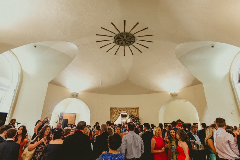 Crowd of guests at a New Orleans wedding reception in a historic venue.
