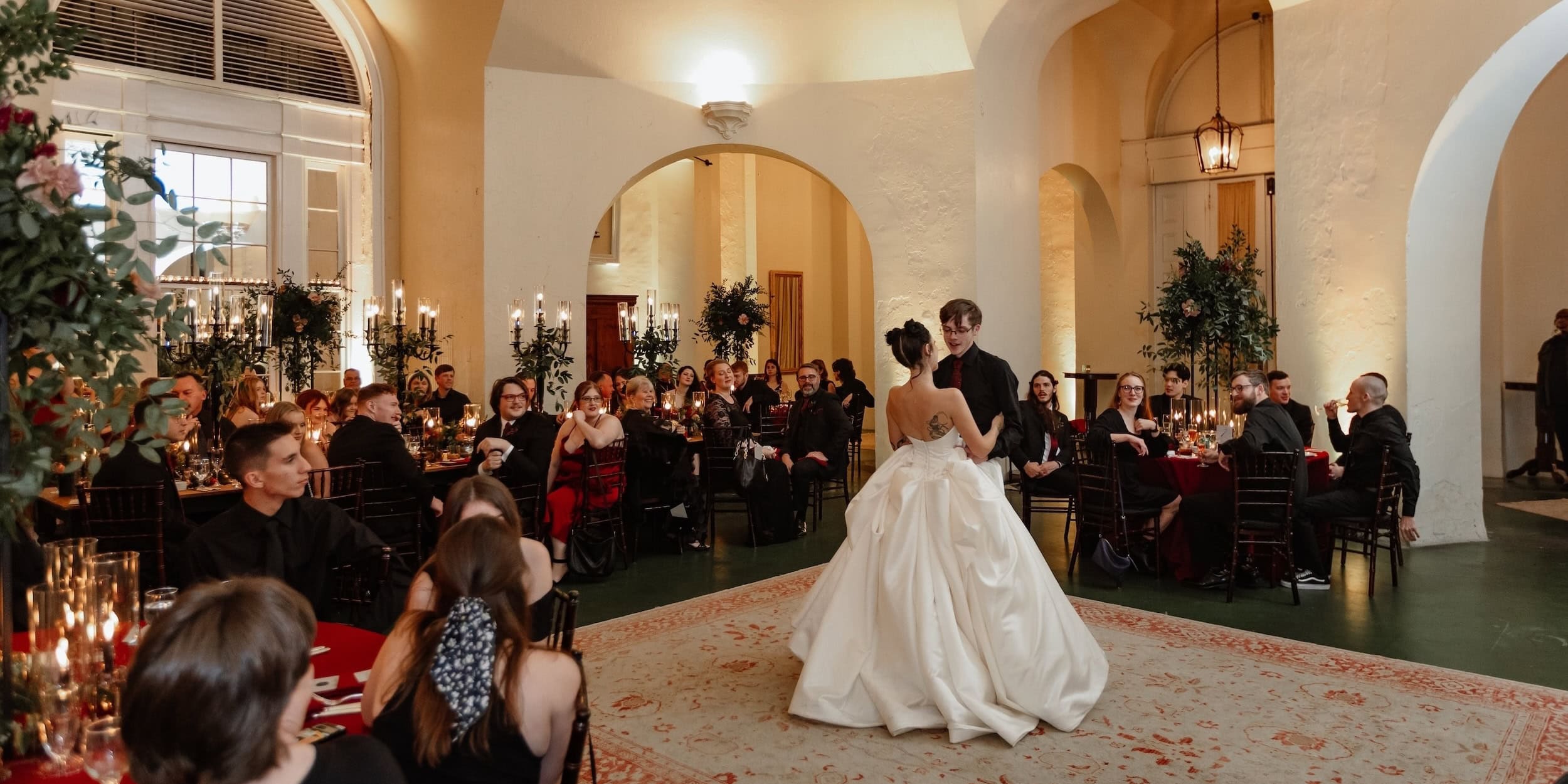 Wedding couple dancing at reception at Latrobe's in New Orleans with guests.