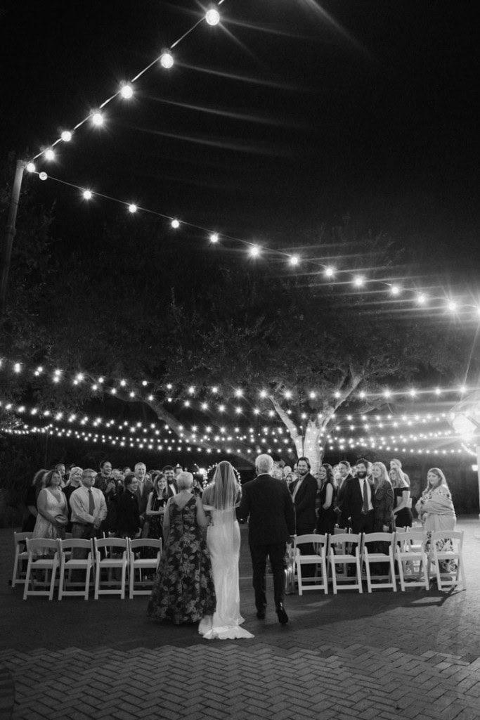 Wedding ceremony at night with string lights and guests in New Orleans.