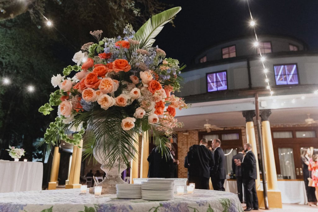 Elegant wedding reception with floral centerpiece and guests at the Audubon Tea Room in New Orleans.