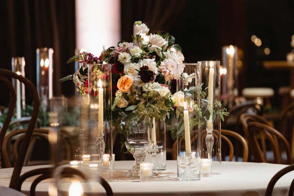 Beautiful wedding table centerpiece with flowers and candles in New Orleans venue.