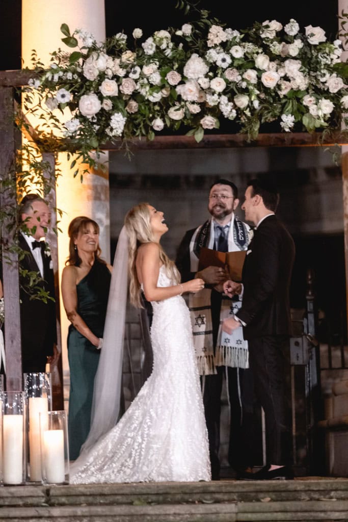 New Orleans wedding ceremony with bride, groom, and officiant at night.