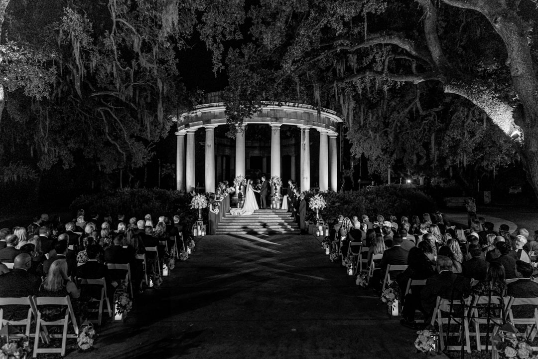 Nighttime wedding ceremony in New Orleans with guests and floral decor.