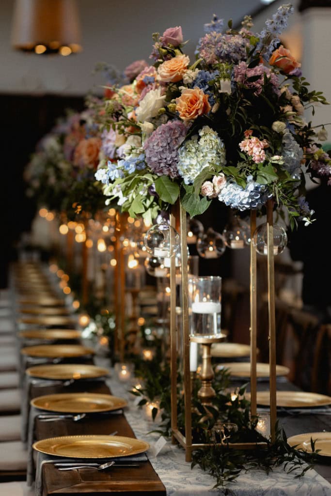 Beautiful floral centerpiece with candles at wedding reception at the Audubon Tea Room in New Orleans.