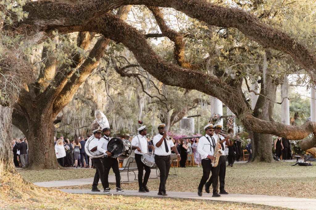 Jazz band performing outdoors in New Orleans park for wedding celebration.