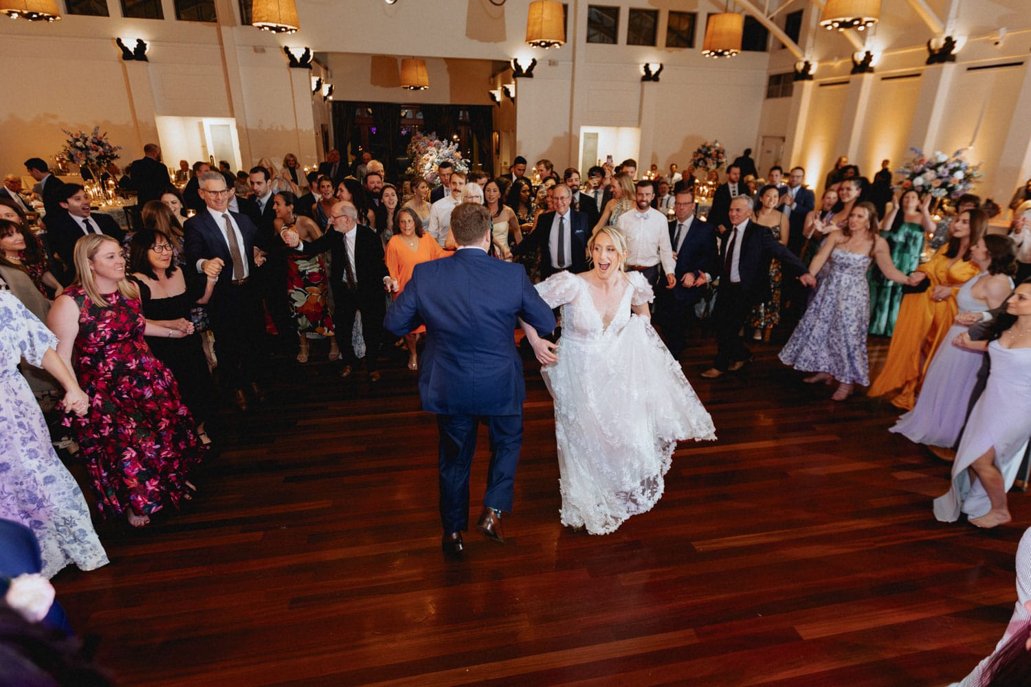 Bride and groom dancing in the middle of a circle of guests at wedding reception at the Audubon Tea Room in New Orleans.