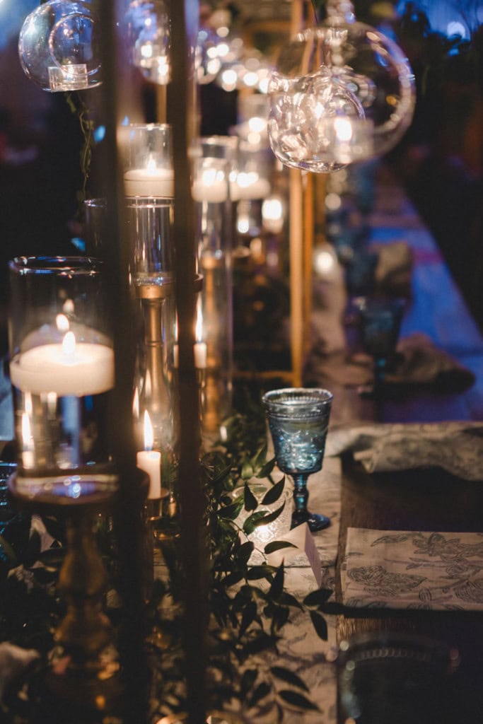 Beautiful wedding reception table with candles and hanging glass globes in New Orleans.