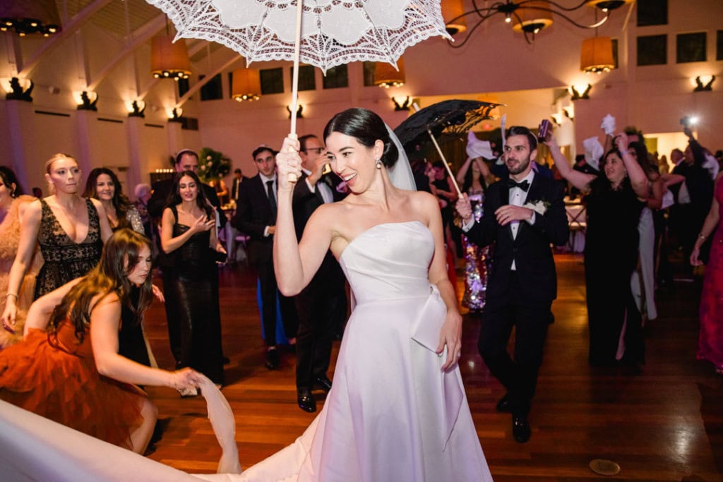 Bride dancing with umbrella at wedding reception in New Orleans.