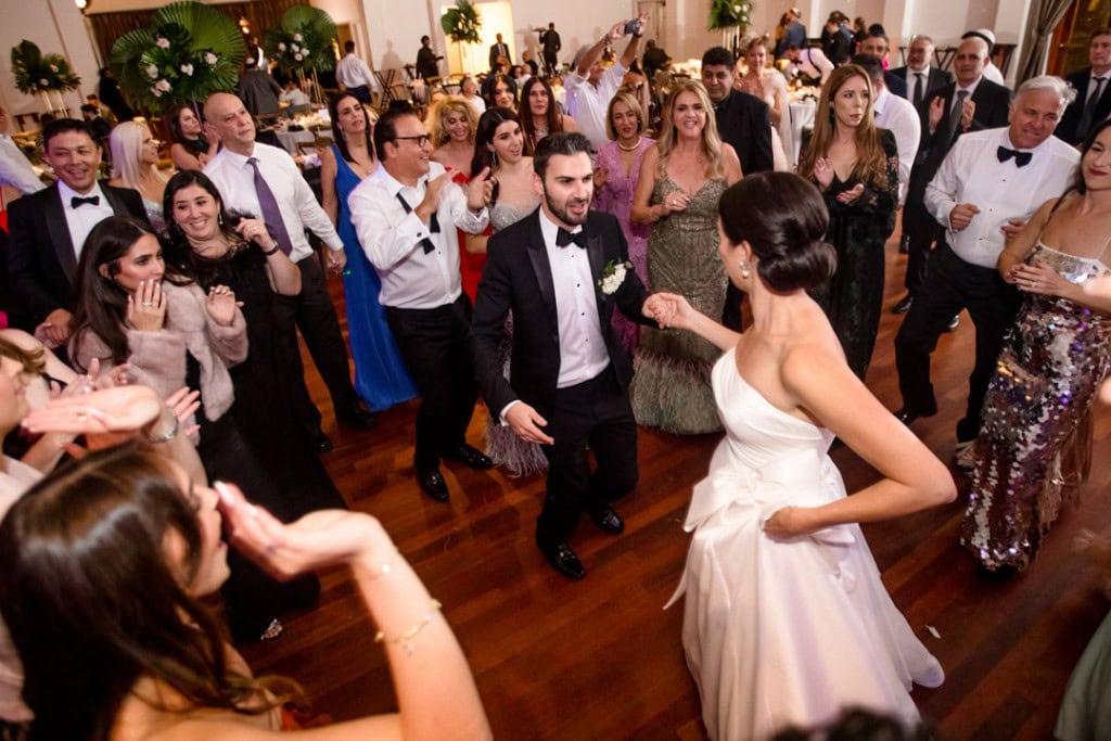 Bride and groom dancing with guests at New Orleans wedding reception.
