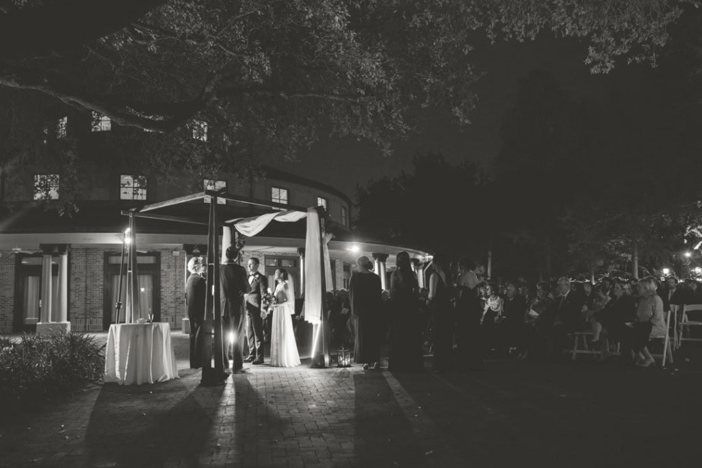 Couple gets married under a chuppah at the Audubon Tea Room in New Orleans at night.